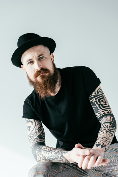 barbudo tatuado hombre en sombrero mirando cámara aislada en blanco
 - Foto, imagen
