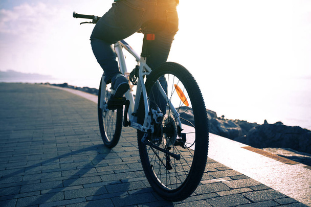 cyclist riding bike in seaside path during sunrise - Foto, Imagen