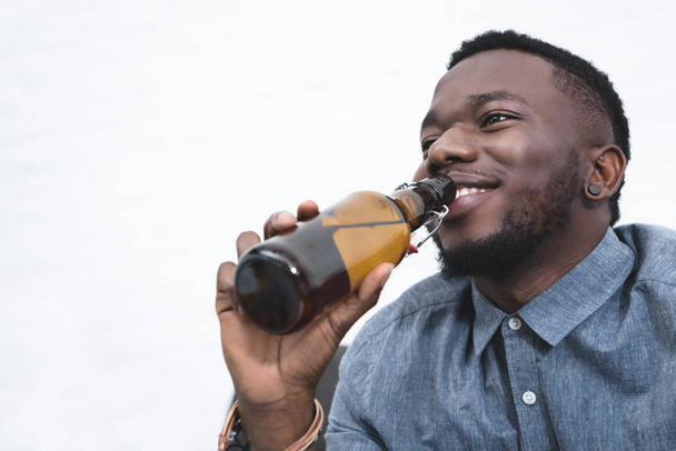 Handsome african american man drinking beer from bottle - Foto, Bild
