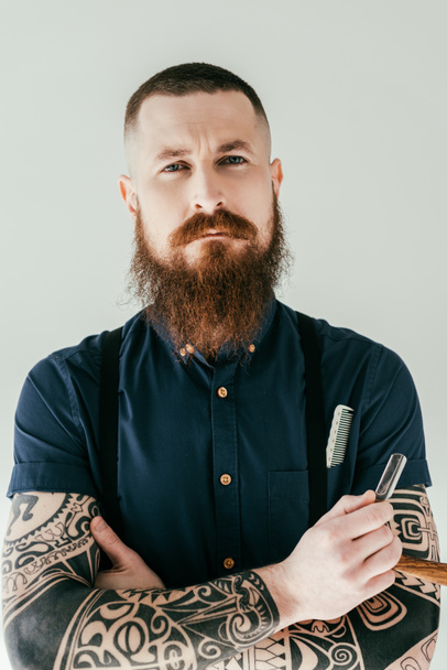 tattooed man holding razor and looking at camera isolated on white - Photo, Image
