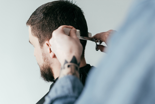 imagem cortada de barbeiro corte de cabelo do cliente na barbearia isolado em branco
 - Foto, Imagem