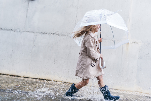 little girl with blue eyes  and big clear umbrella. - Foto, afbeelding