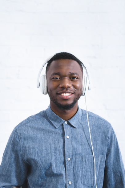 Handsome african american man listening to music in headphones - 写真・画像