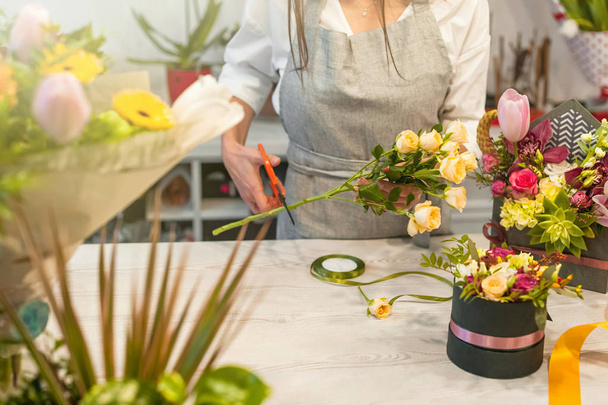 Vrouwelijke bloemist met behulp van schaar maken prachtige boeket op bloemenwinkel - Foto, afbeelding