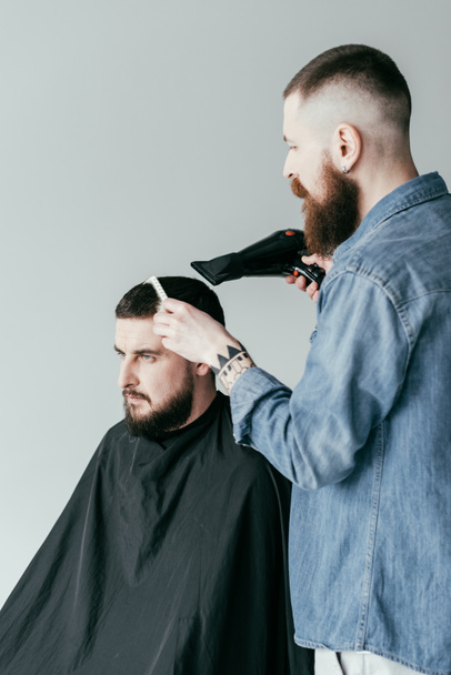 fryzjer, suszenie włosów klienta o fryzjera na białym tle - Zdjęcie, obraz