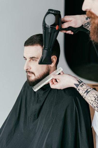 przycięte zdjęcie Fryzjer suszenia broda klienta o fryzjera - Zdjęcie, obraz