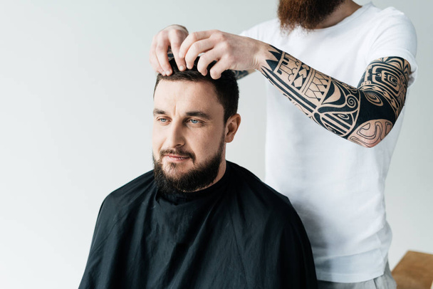 immagine ritagliata di parrucchiere styling capelli dei clienti al barbiere isolato su bianco
 - Foto, immagini
