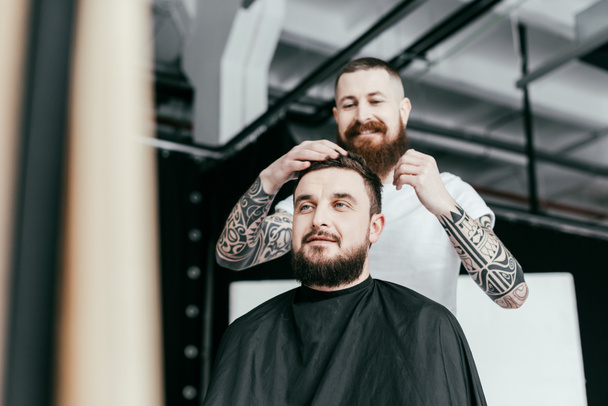 barber styling customer hair at barbershop - Foto, Imagen