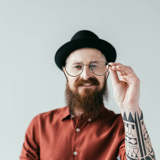 smiling bearded handsome man holding glasses isolated on white - Foto, imagen