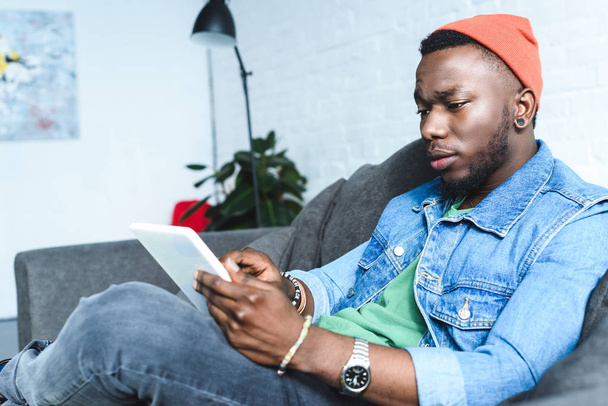 Knappe Afro-Amerikaanse man met behulp van digitale tablet - Foto, afbeelding