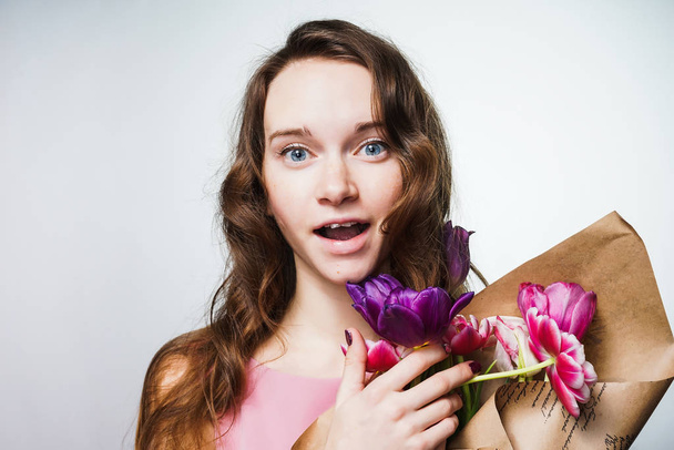 beautiful surprised young woman holding a big bouquet of flowers, celebrating Mother's Day - Foto, Bild