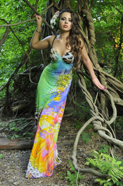 Beautiful brunette model posing pretty at tropical jungle wearing designers colorful dress - Valokuva, kuva
