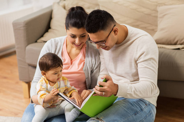 famille heureuse avec livre de lecture de bébé à la maison
 - Photo, image
