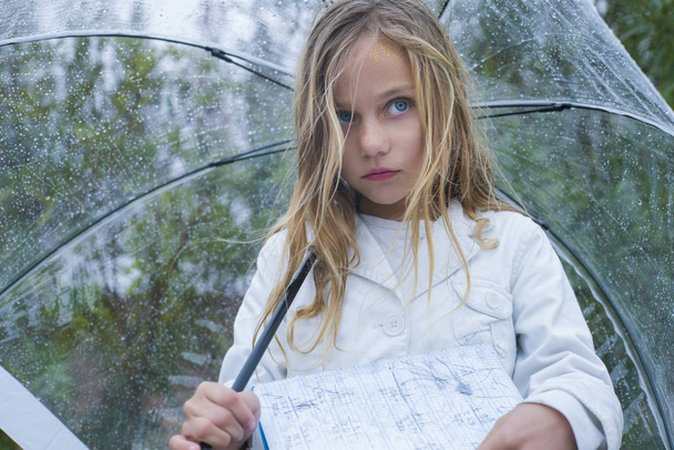 little girl with blue eyes  and big clear umbrella. - Foto, afbeelding