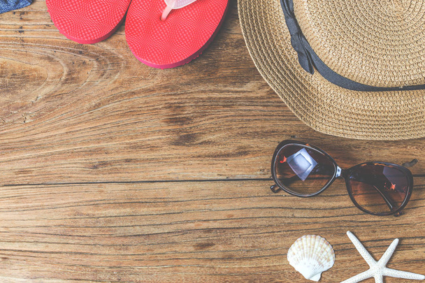 Straw hat and sunglasses on wood - 写真・画像