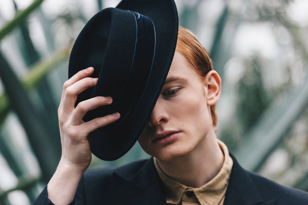 pensive handsome young red-haired man wearing black hat - Photo, image