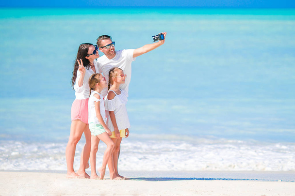 Man taking a photo of his family on the beach. Family vacation - Photo, Image
