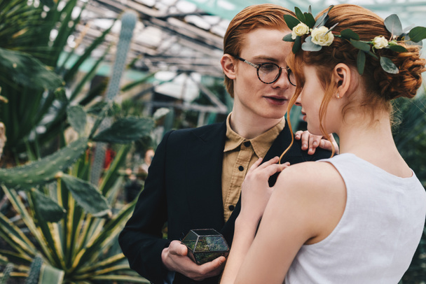 beautiful young red-haired wedding couple with engagement ring in botanical garden - Photo, Image