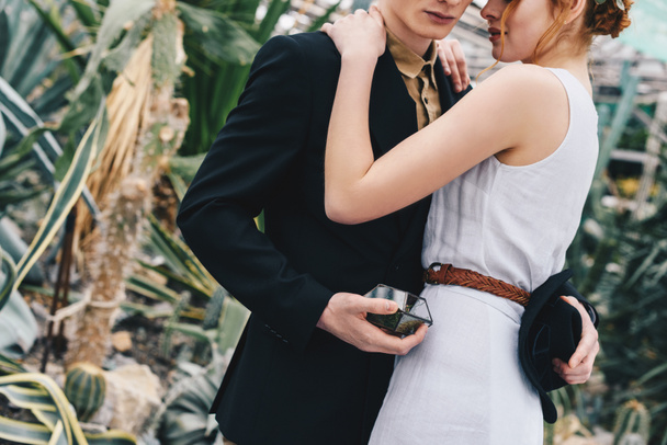 cropped shot of young wedding couple hugging in botanical garden - Фото, изображение