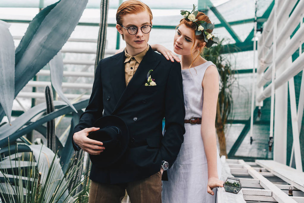 beautiful stylish young wedding couple standing together in botanical garden - Fotoğraf, Görsel