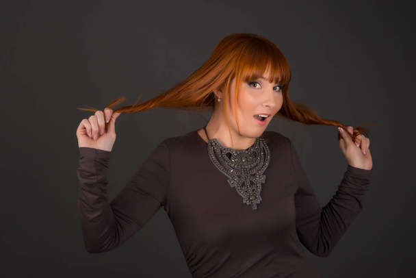 Vonzó nő pózol stúdió: piros vagy gyömbér hajú modell - Fotó, kép