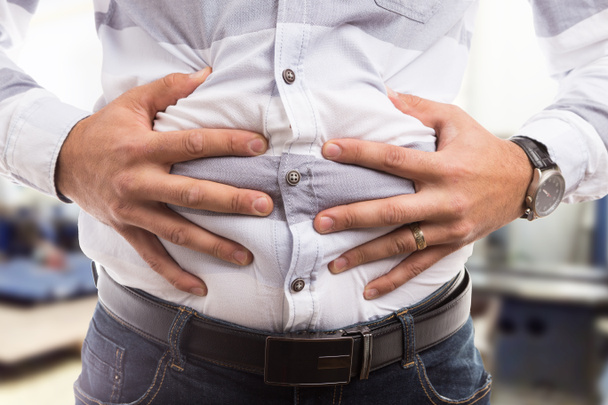 Homme pressant l'abdomen ou le ventre gonflé comme proble de flatulence de crampe
 - Photo, image