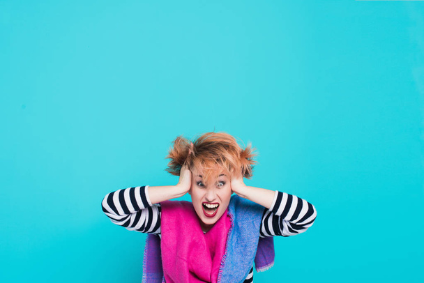 Girl with red hair holding her head shouting. Stress and hysterical. negative emotions. Studio shot. Blue  background - Fotografie, Obrázek