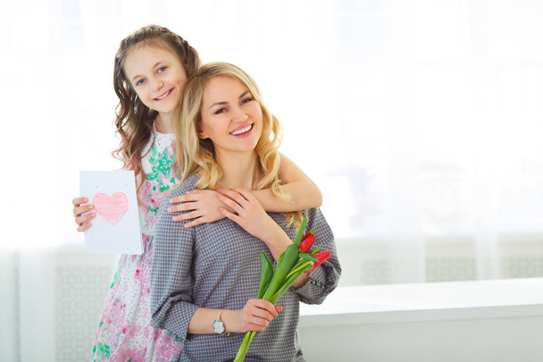 Dcera dala matce kytici tulipánů a pohlednice s vlastníma rukama. - Fotografie, Obrázek