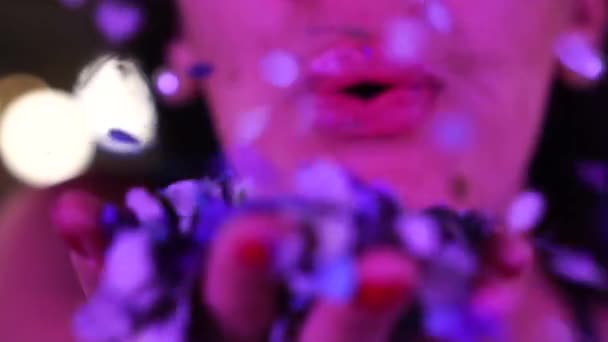Tyttö puhaltaa värikkäitä konfetteja
 - Materiaali, video