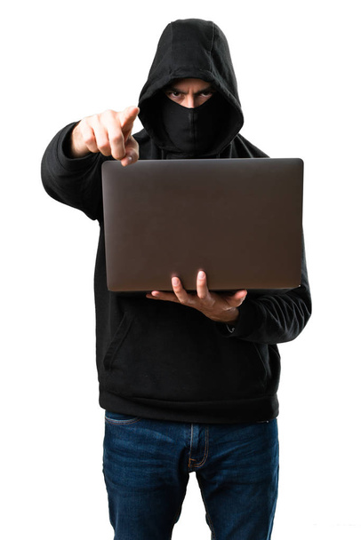 Hacker con su computadora apuntando al frente en blanco aislado
 - Foto, imagen
