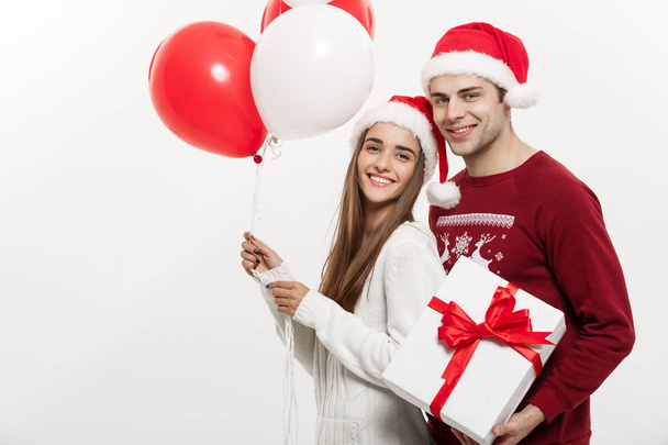 Christmas Concept - Young girlfriend holding balloon is hugging  - Φωτογραφία, εικόνα