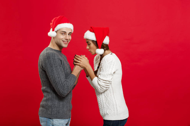 Χριστούγεννα Concept - νέοι κομψό ζευγάρι κρατώντας το χέρι κάθε άλλο - Φωτογραφία, εικόνα