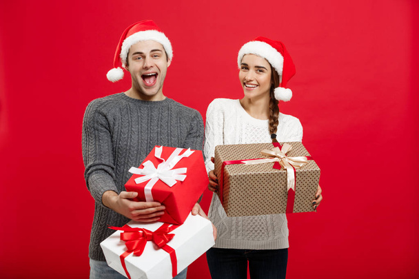 Conceito de Natal - Jovem casal atraente segurando um monte de presentes desfrutar de compras e celebrar no dia de Natal
 - Foto, Imagem