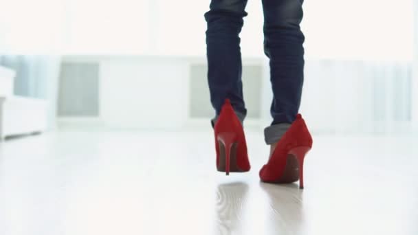 Ein kleines Mädchen in mütterlichen roten Schuhen läuft durch das Haus. zurück - Filmmaterial, Video