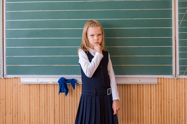 Πρώτου βαθμού μαθητή εγγράφως σχετικά με πράσινη μαυροπίνακα στο μάθημα σχολείο κορίτσι - Φωτογραφία, εικόνα