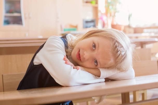 girl in the first grade, is sitting at the desk - Fotoğraf, Görsel
