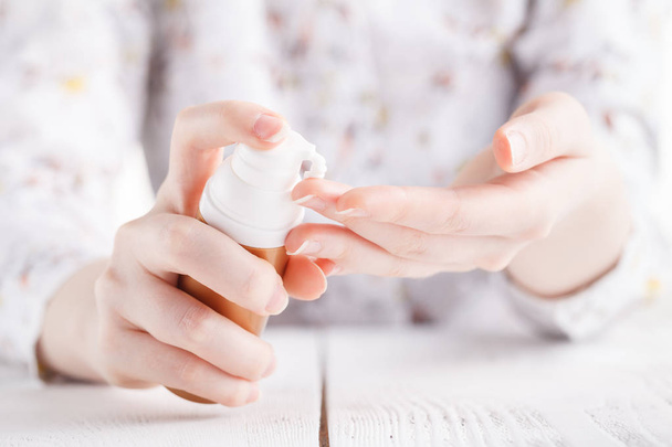 Young woman hands applying moisturizing cream to her skin - Foto, afbeelding
