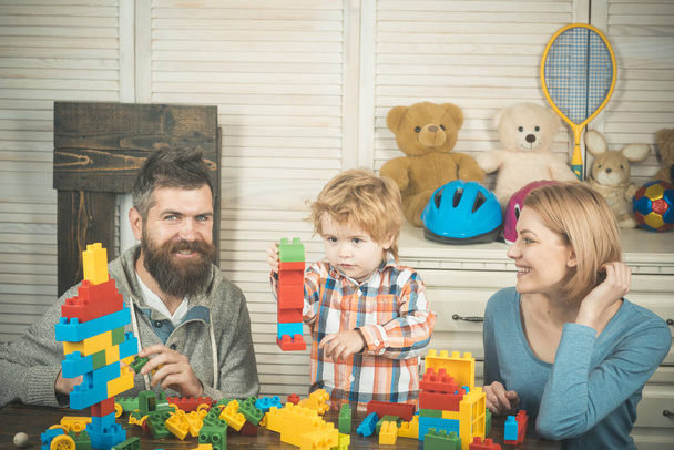 Father, mother and son in playroom on light wooden background. - 写真・画像
