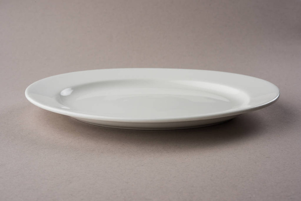leere weiße Keramik ovale oder rechteckige Platte isoliert auf weißem Hintergrund - Foto, Bild