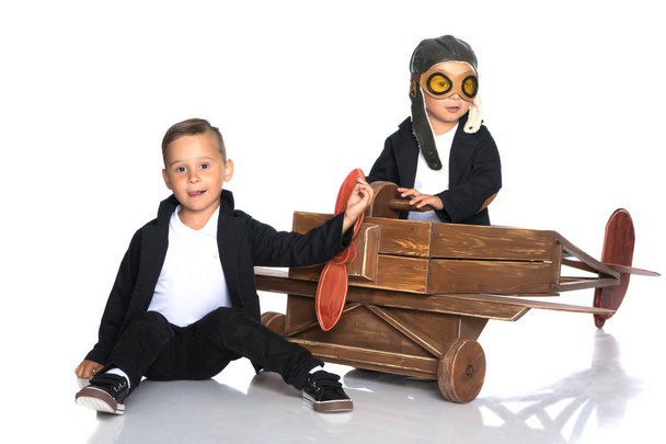 Two little boys are playing with a toy airplane. - Foto, Bild
