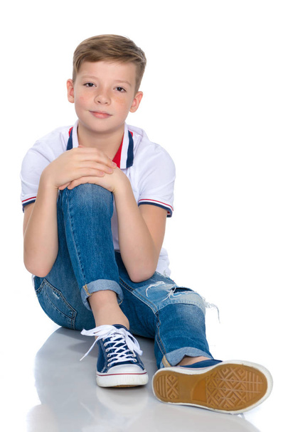 Fashionable boy teen sitting on the floor. - Foto, afbeelding