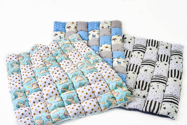 Bündel bunter Patchwork-Bettdecken mit Einhorn und Sternen auf weißem Hintergrund - drei Teile - Foto, Bild