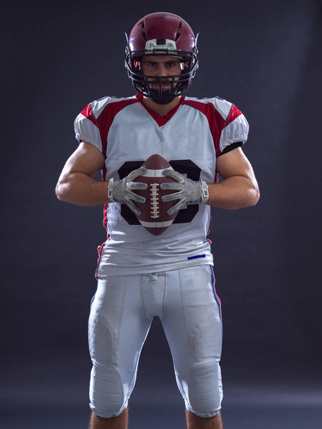 Portrait of a strong muscular American Football Player isolated on gray - Foto, afbeelding
