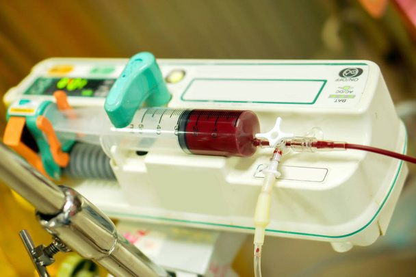 Blood in syringe pump machine transferring blood to a sick newborn baby in a hospital. - Valokuva, kuva