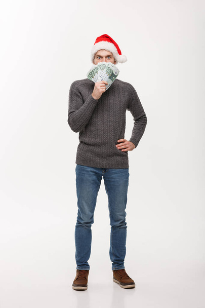 Concept de vacances - jeune homme barbe tenant de l'argent devant sur fond blanc
 - Photo, image