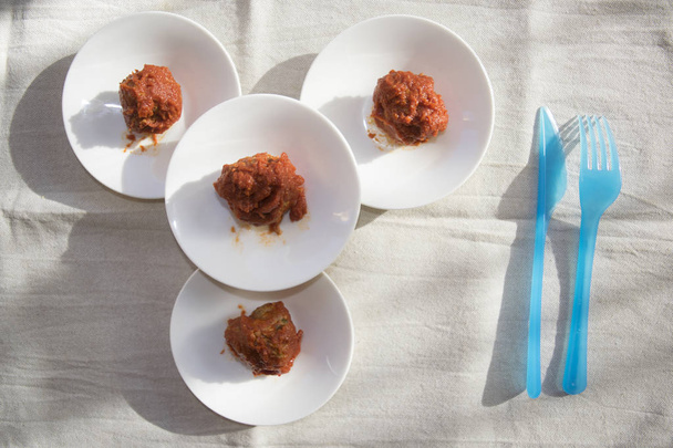 4つの白い受け皿とミートボールのトマトソース - 写真・画像
