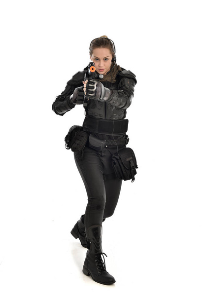 täyspitkä muotokuva naissotilas yllään musta taktinen panssari, pitämällä kivääri ase, eristetty valkoinen studio tausta
. - Valokuva, kuva