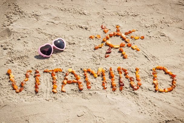 Sunglasses, inscription vitamin D and shape of sun at beach, summer time and healthy lifestyle concept - Foto, immagini
