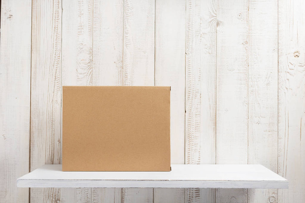 cardboard box on wooden shelf - Фото, изображение