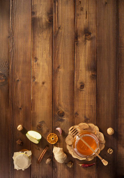 glass jar of honey on wood - Foto, afbeelding